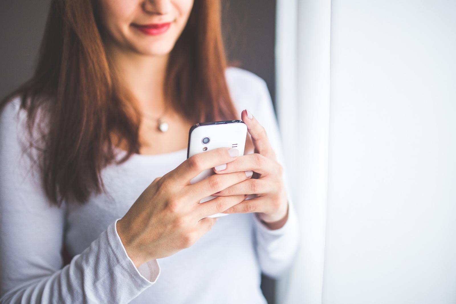osoba trzymająca telefon