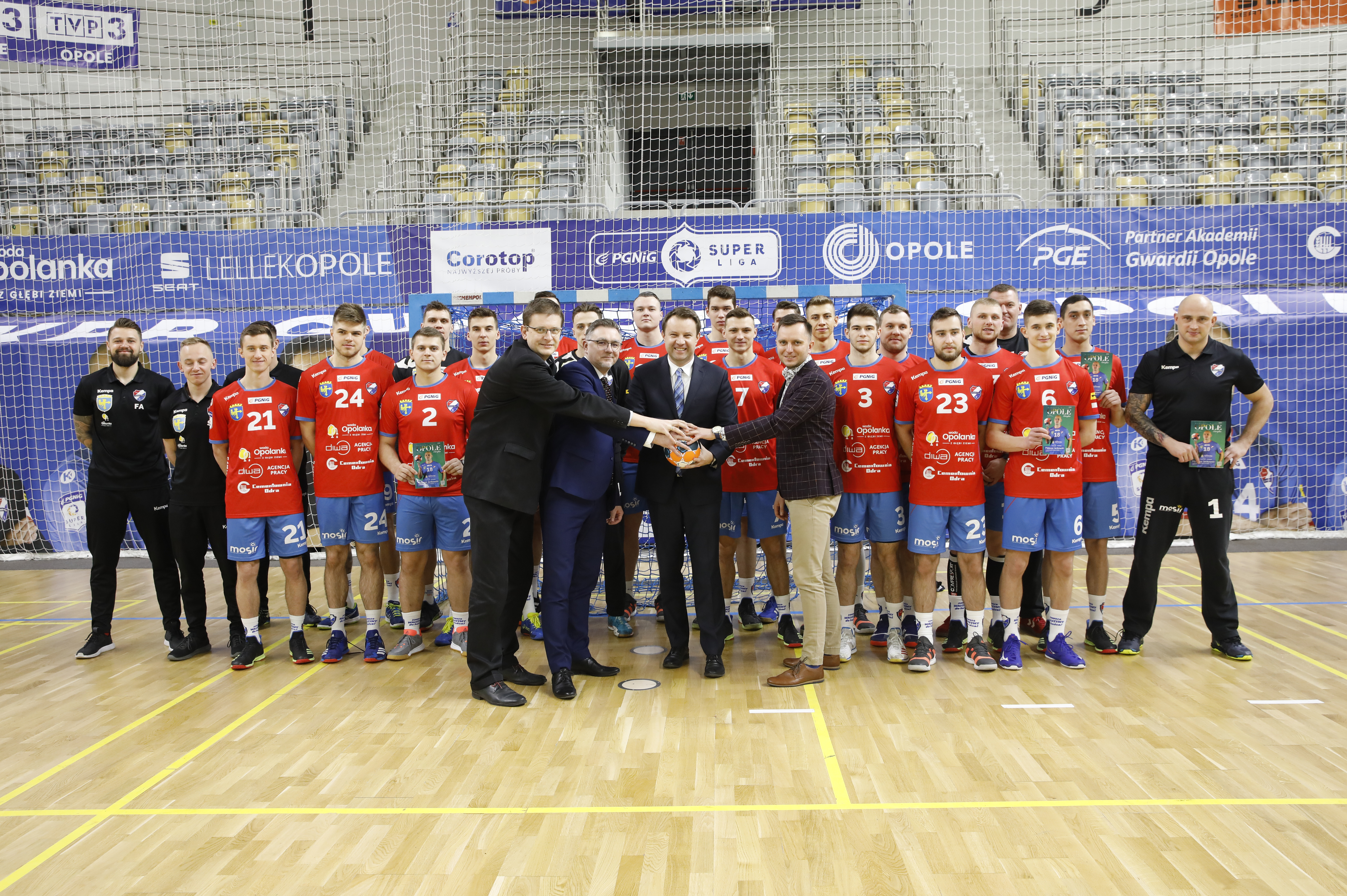 Zdjęcie zawodników i działaczy Gwardii Opole stojących przy bramce z prezydentem Arkadiuszem Wiśniewskim, Przemysławem Zychem i naczelnikiem wydziału sportu - Marcinem Saganem.