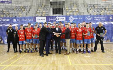 Zdjęcie zawodników i działaczy Gwardii Opole stojących przy bramce z prezydentem Arkadiuszem Wiśniewskim, Przemysławem Zychem i naczelnikiem wydziału sportu - Marcinem Saganem.