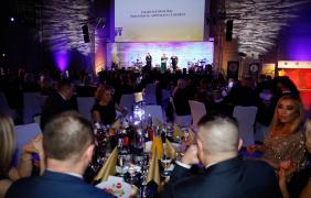 Goście przy stolikach wpatrujący się w scenę